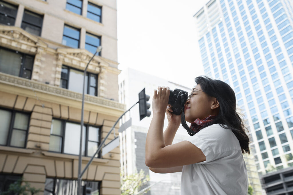 A woman captures a photo of a building